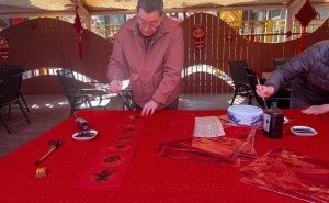 手写春联送祝福，年味浓浓满社区