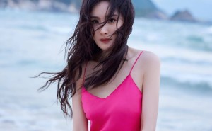 杨幂38岁海滩粉裙秀，纤腰长腿诠释时尚新态度