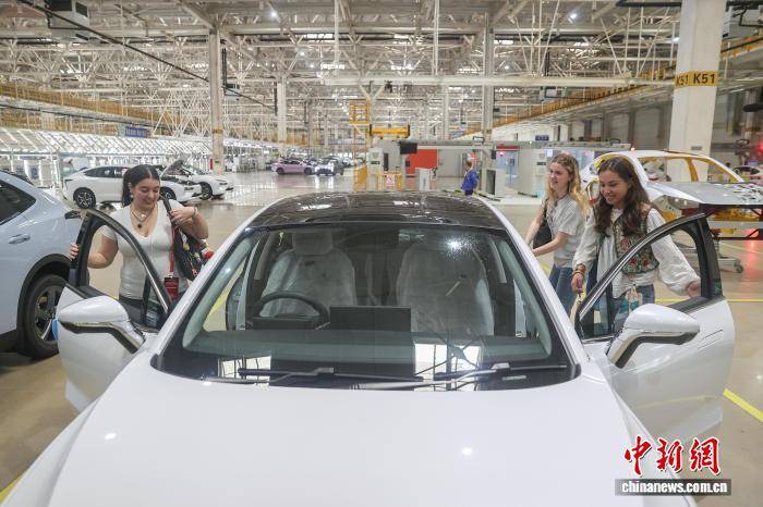 外國青年學(xué)生準(zhǔn)備體驗(yàn)新能源汽車